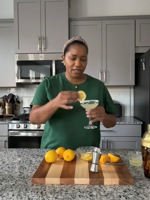 garnishing martini glass with a lemon slice. 