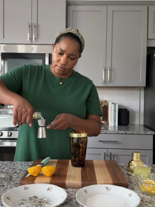 Adding triple sec to a cocktail shaker.