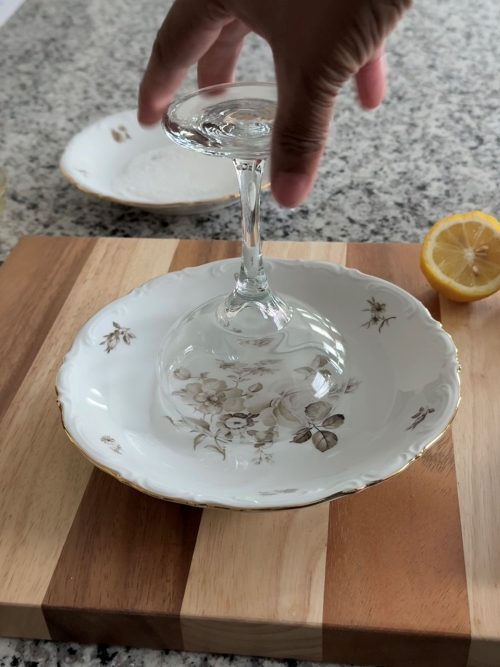 Rimming a martini glass with simple syrup.