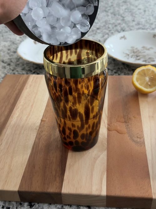 Adding ice to a cocktail shaker.