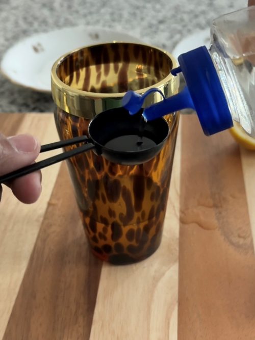 Adding simple syrup to cocktail shaker.