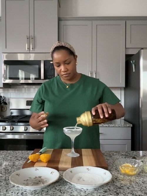 Pouring a lemon drop martini into a martini glass.